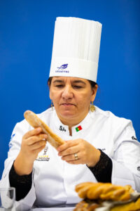 Padeira Elisabte Ferreira a segurar um pão e examiná-lo para concurso
